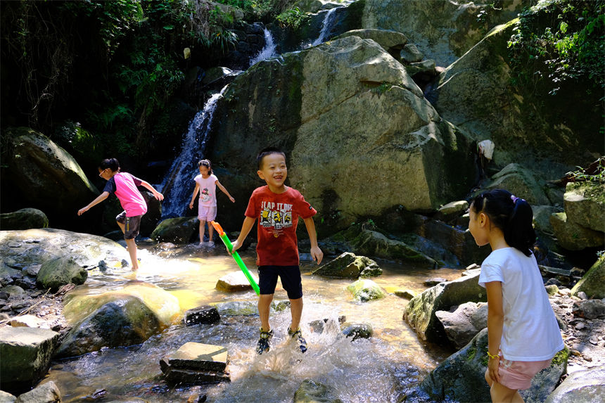 7月10日，孩子們在南山清水溪戲水玩耍，盡享清涼。郭旭攝