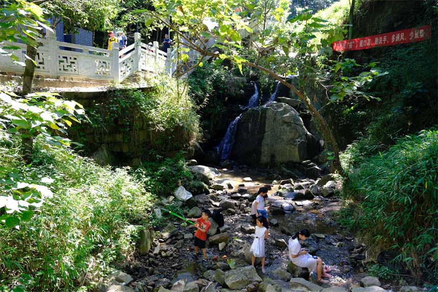 7月10日，孩子們在南山清水溪戲水玩耍，盡享清涼。郭旭攝