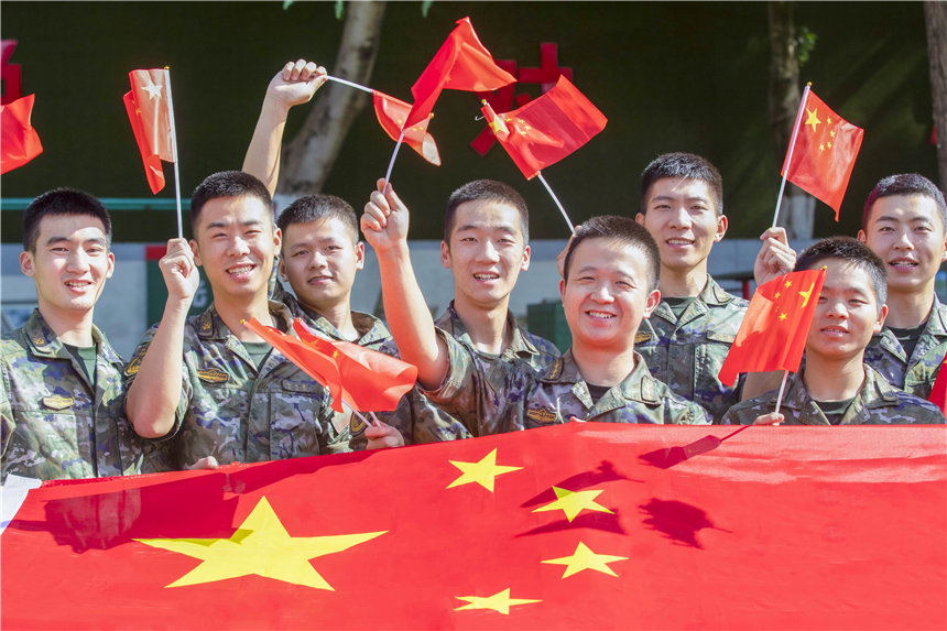 武警官兵揮舞國(guó)旗，祝福祖國(guó)繁榮昌盛。李東攝