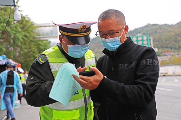 交通卡口防疫人員在查看入彭群眾健康碼。趙勇攝