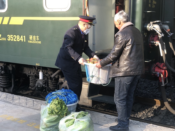 吳洪江幫上下車村民搭把手。張章攝