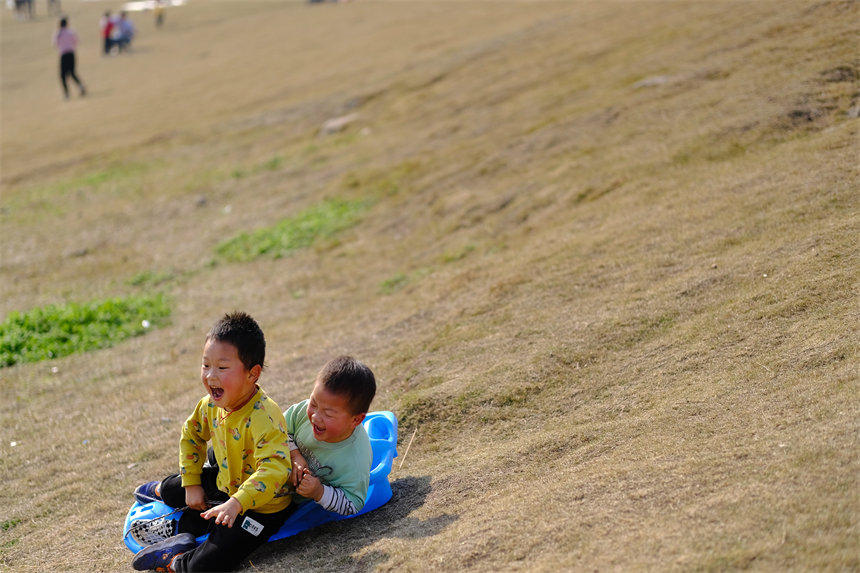 孩子們沐浴著陽(yáng)光，在草坪上盡情撒歡。郭旭攝