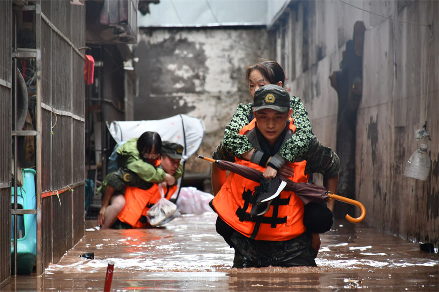 圖為武警官兵轉(zhuǎn)移受災(zāi)群眾。徐優(yōu)攝