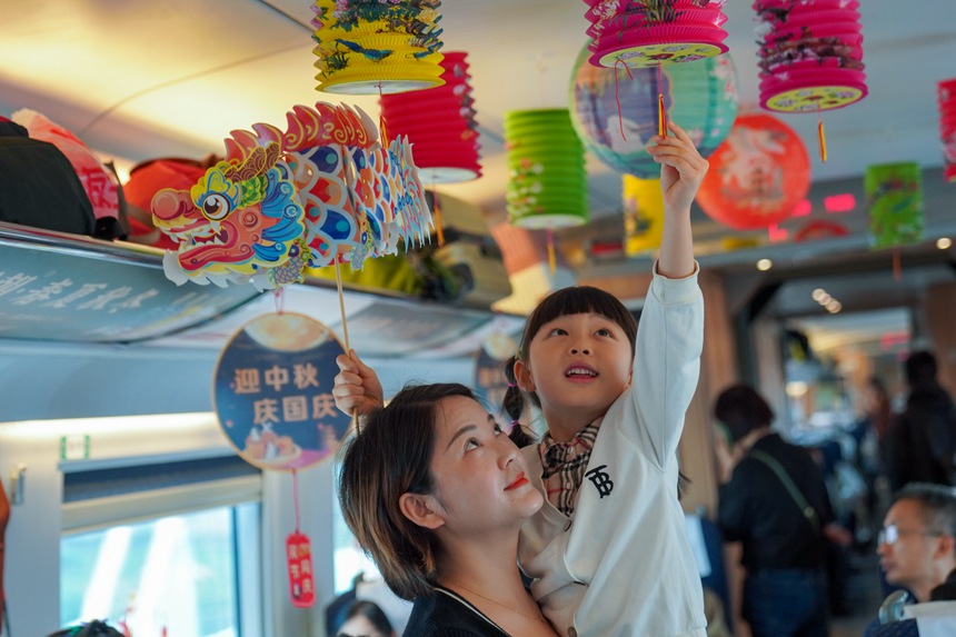 重慶西開往貴陽北的G4859次列車上，旅客打卡中秋國慶文化車廂。李文航攝