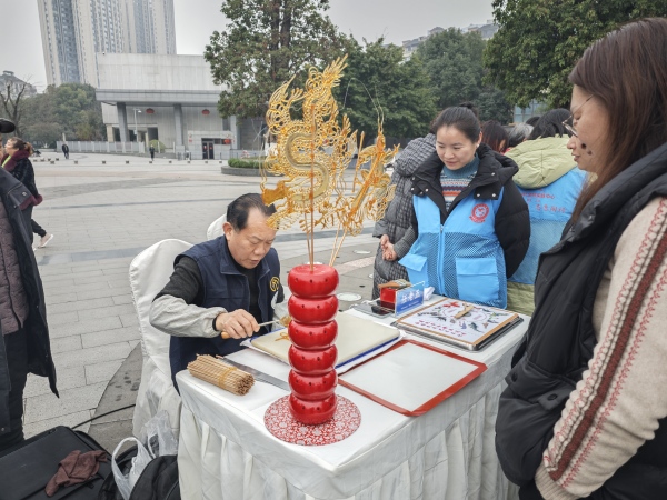 傳統(tǒng)手工藝糖畫傳承人任老五現(xiàn)場制作糖畫。石馬河街道供圖