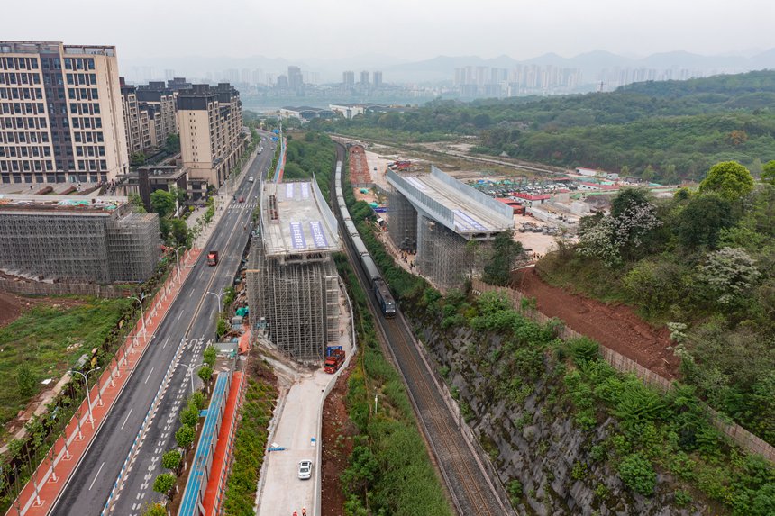 4月10日，慢火車經(jīng)過(guò)大渡口區(qū)上跨成渝鐵路轉(zhuǎn)體橋施工區(qū)域。黃瀟彧攝