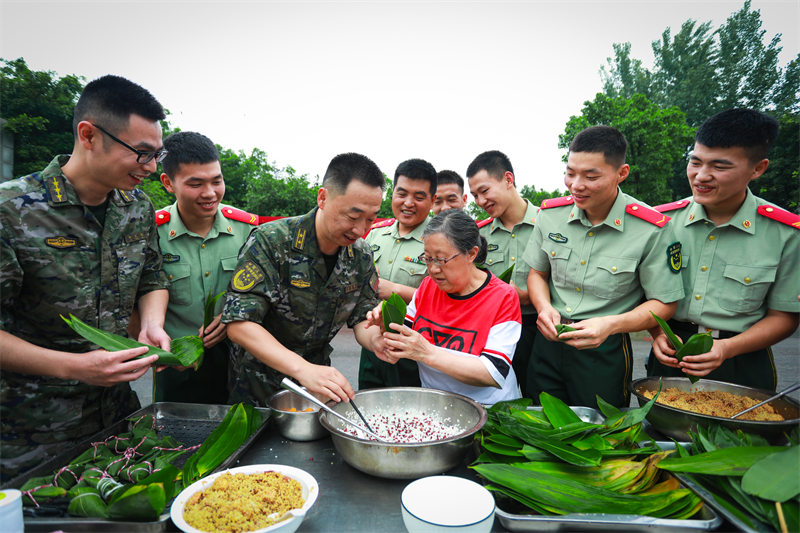 “兵媽媽”陳莉萍與武警官兵一起包粽子。郭傳伍攝