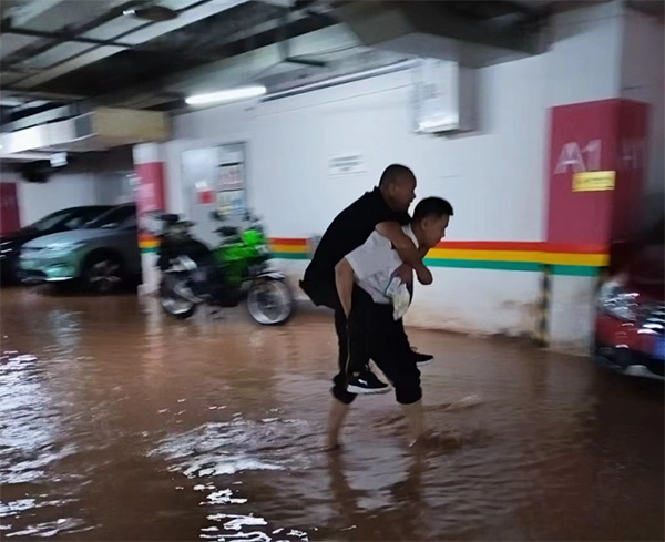 物業(yè)人員背著業(yè)主淌水至干凈區(qū)域。東原仁知物業(yè)供圖