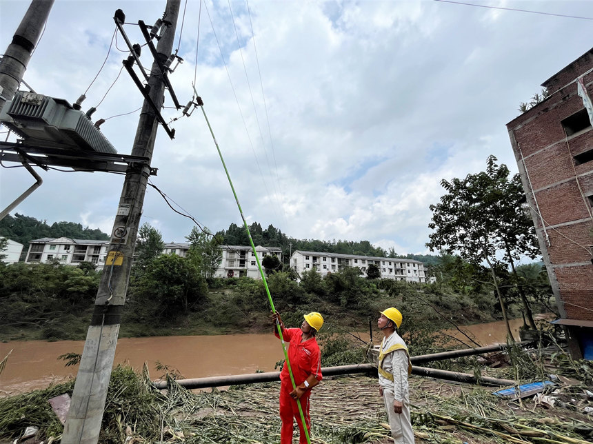 國網(wǎng)重慶豐都供電公司社壇供電所工作人員在洪水退去后恢復電力設施供電。劉遠平攝