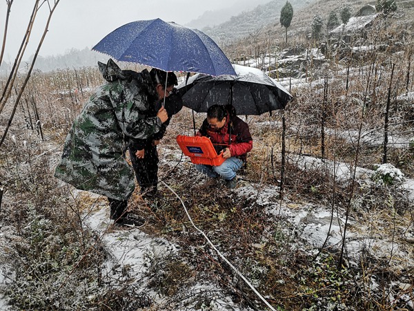 《大雪中的守護(hù)》。踏實(shí)做好地質(zhì)災(zāi)害防治工作，不分春夏秋冬。2023年12月26日，川東南勘察公司地質(zhì)駐守工程師王龍貴（左一）帶領(lǐng)項(xiàng)目組冒著大雪開(kāi)展豐都縣武平鎮(zhèn)徐家院子地面塌陷勘查項(xiàng)目物探工作。楊彬攝