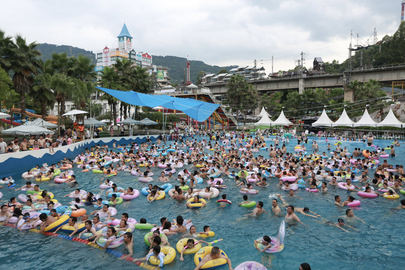 市民游客在水上樂園玩水沖浪。