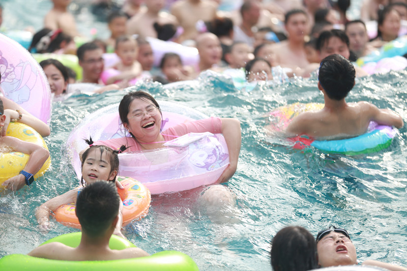 市民游客在水上樂園玩水沖浪。